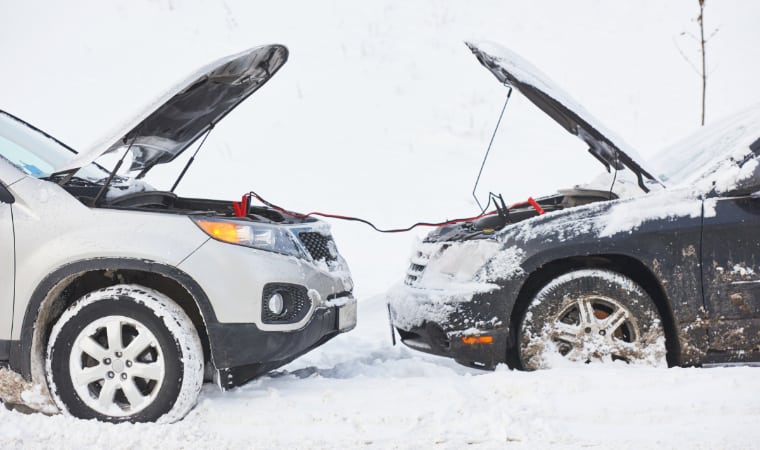 Charging automobile discharged battery by booster jumper cables at winter