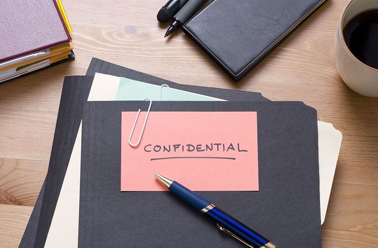 Confidential documents on a wooden table