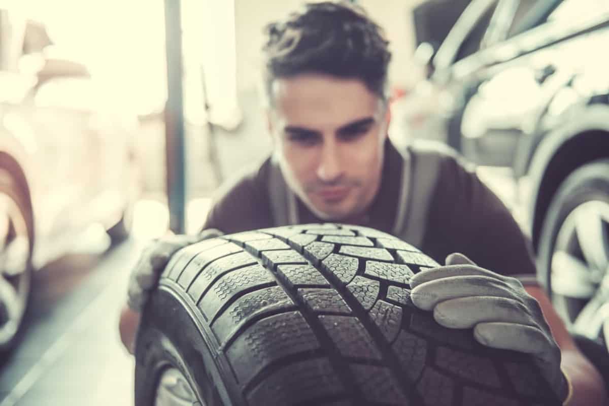 man inspecting a car tire
