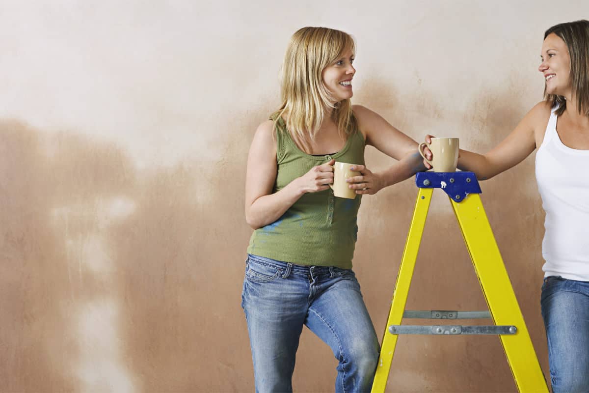 two women leaning on a heavy duty step ladder