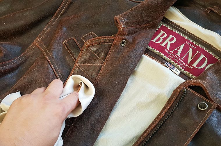 Spot cleaning a brown leather jacket