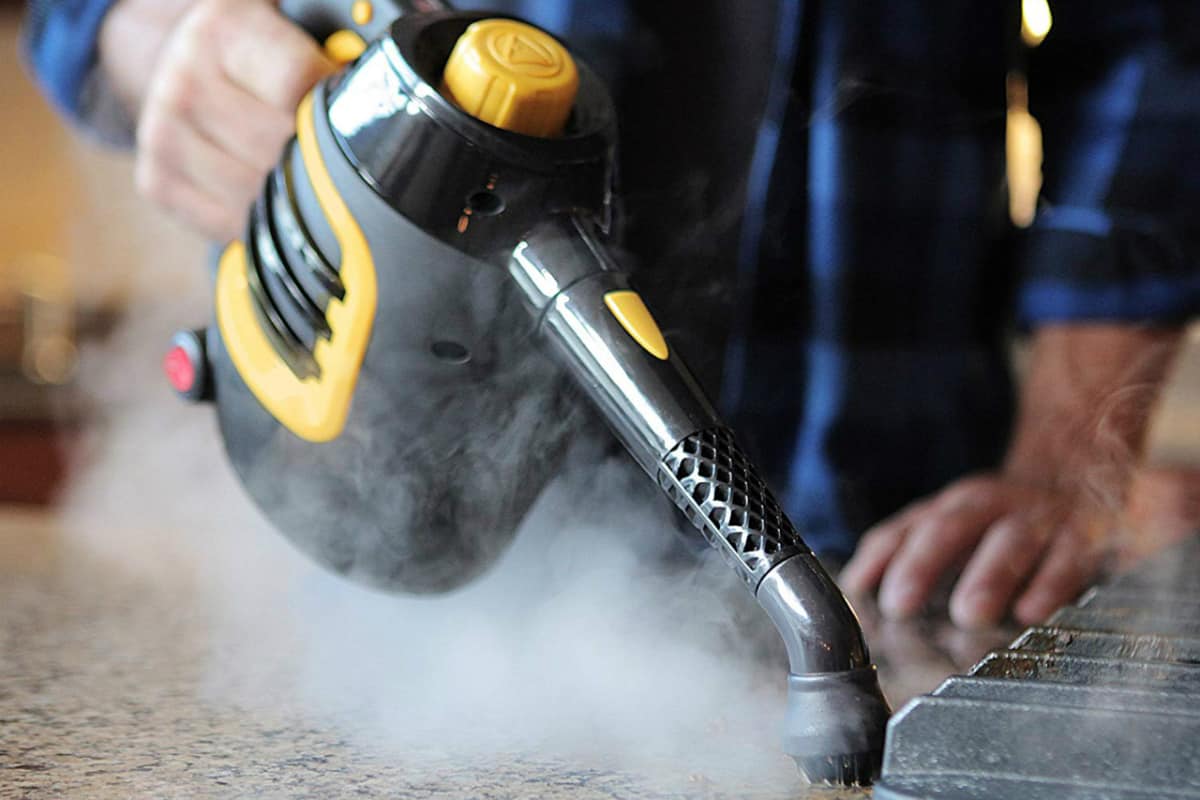 steam cleaning the kitchen counter top with a handheld steam cleaner