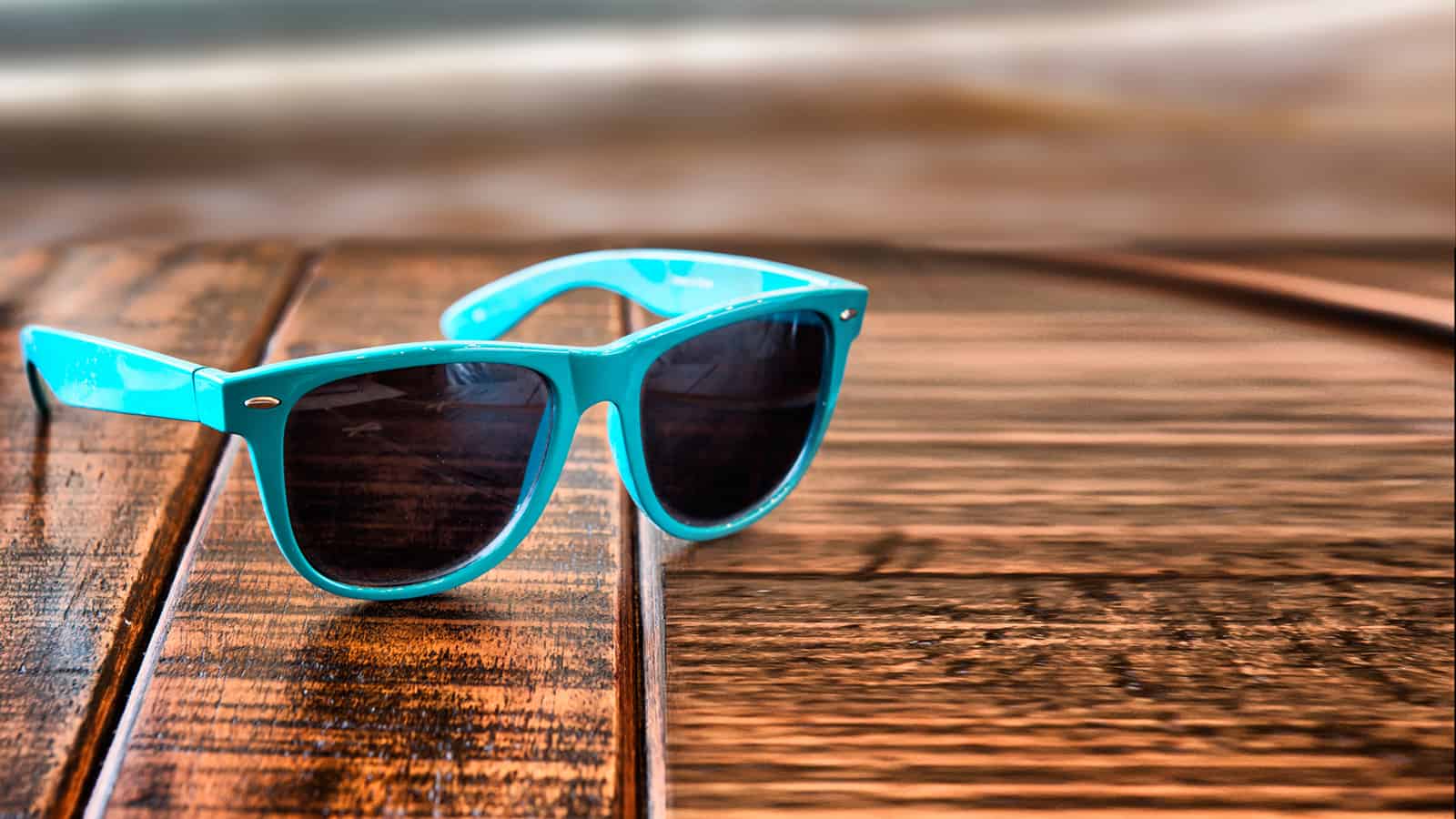 Sunglasses on wooden desk at the summer beach vacation