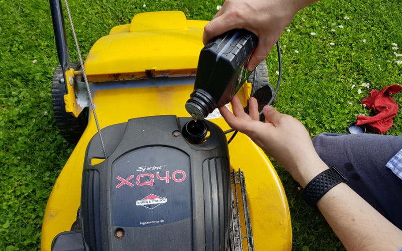 adding oil to a lawn mower