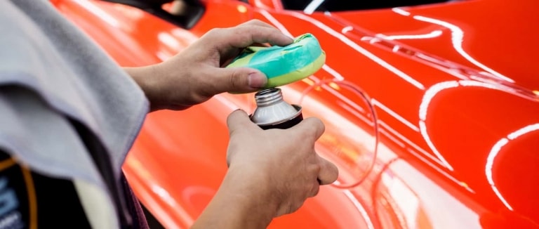 car service worker applying coating on a car