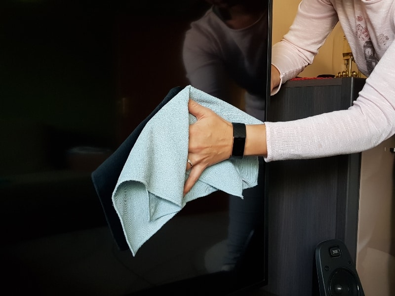 cleaning a flast screen tv with a microfiber cloth