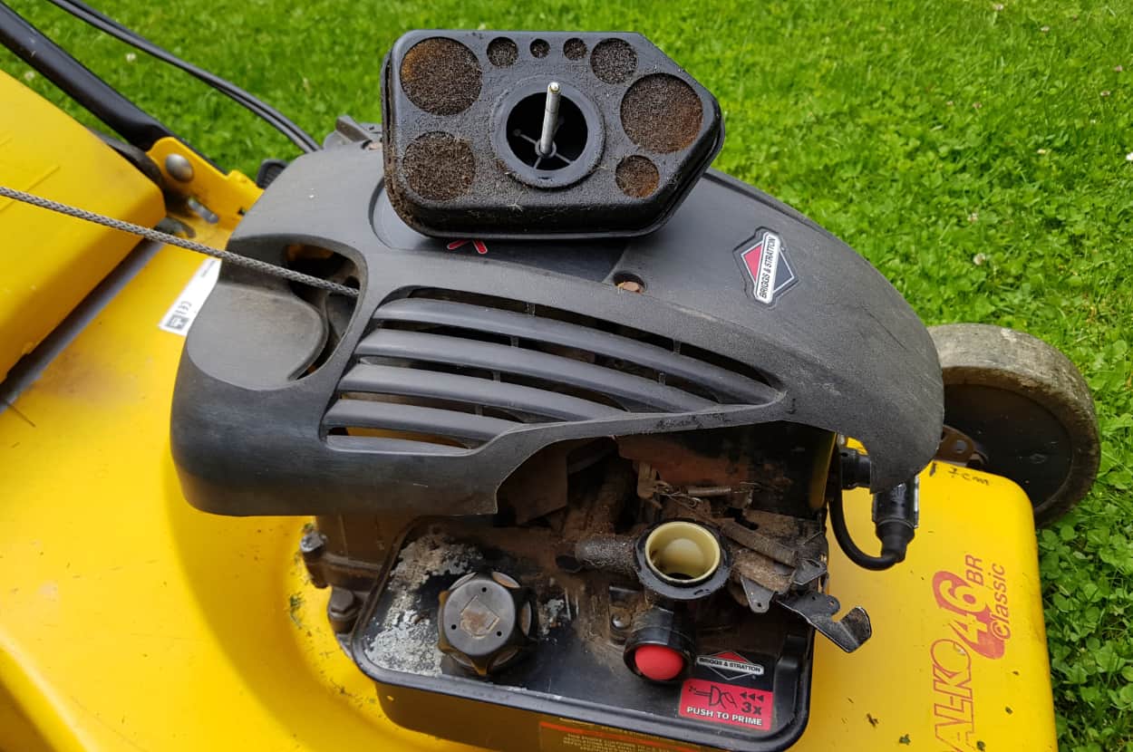 removed air filter placed on top of lawn mower-ft