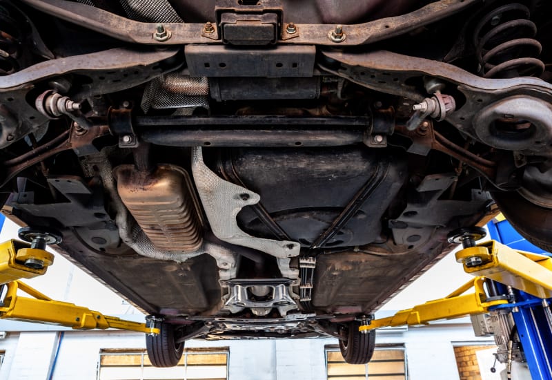 View of car undercarriage when lifted on hydraulic lift