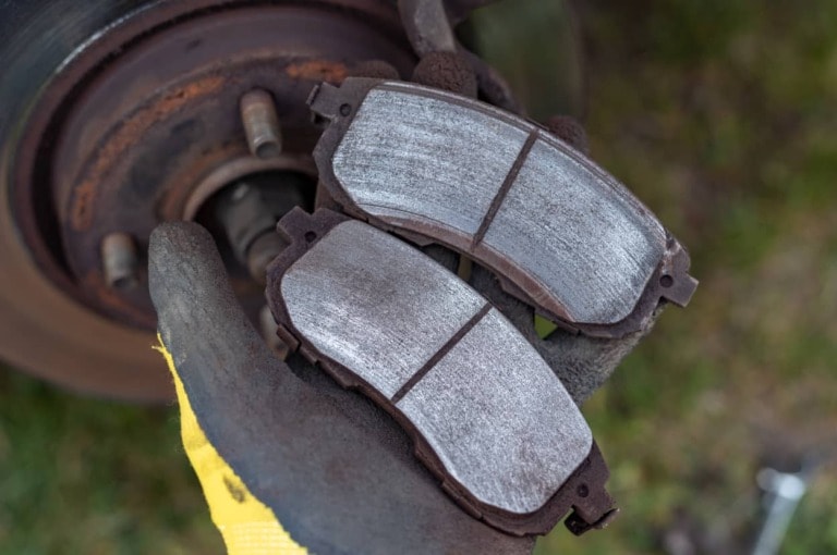 man holds a pair of new brake pads