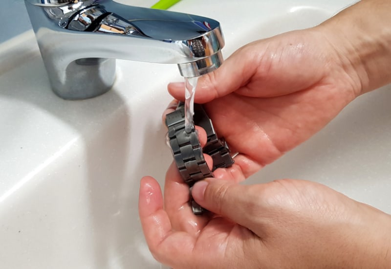 Rinsing a metal watch band with water
