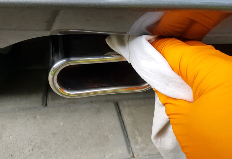 cleaning the exhaust tip with a cloth