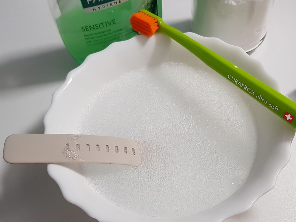 Watch strap in bowl of soapy water