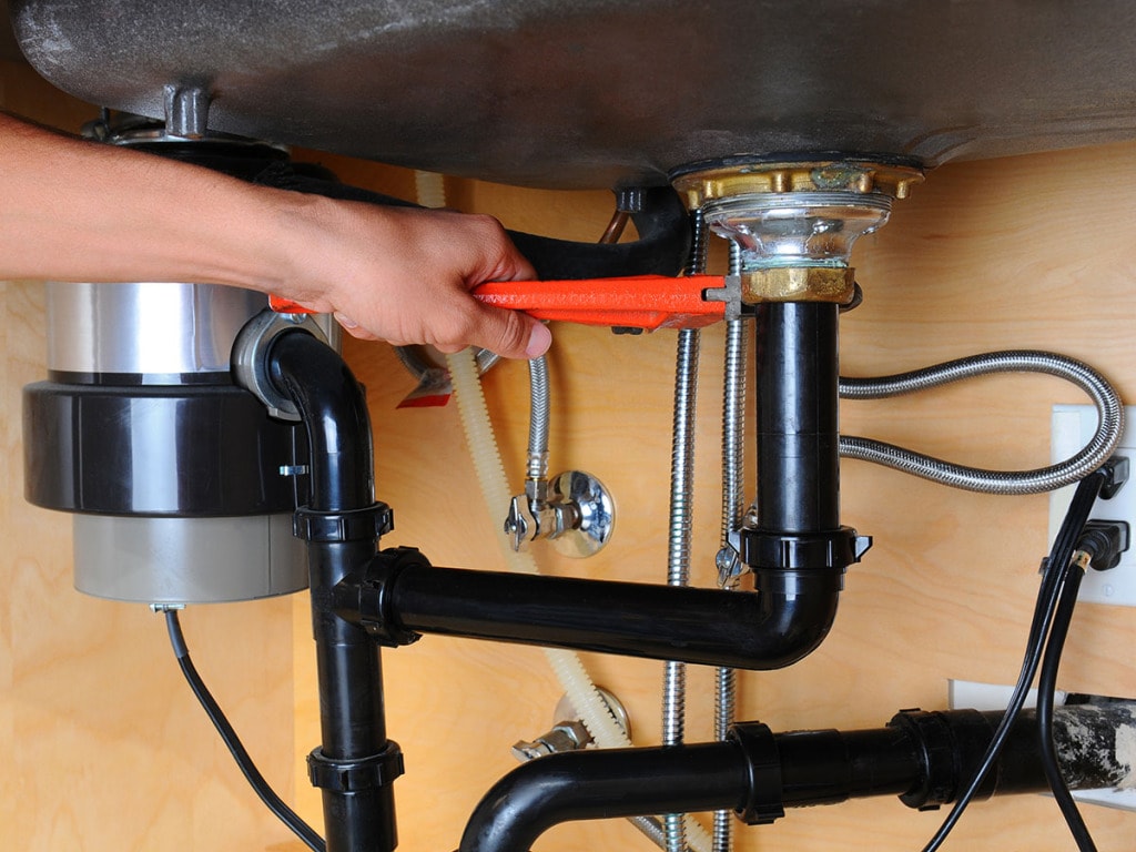 Plumber working under kitchen sink
