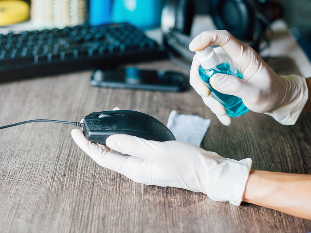 Person cleaning wired mouse